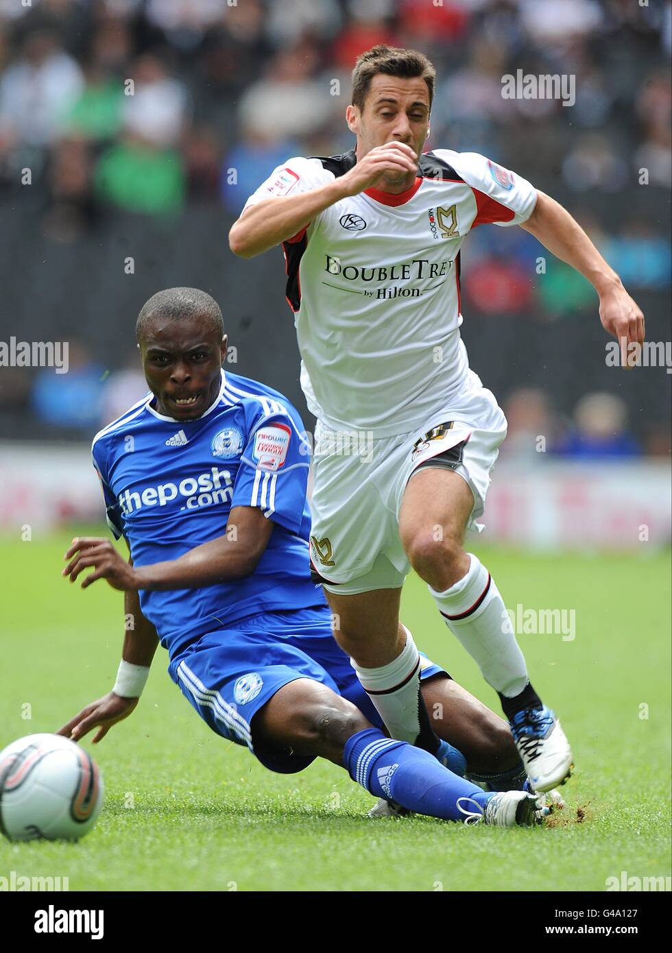 Peterborough United's Gabriel Zakuani (left) tackles Milton Keynes Dons' Sam Baldock Stock Photo