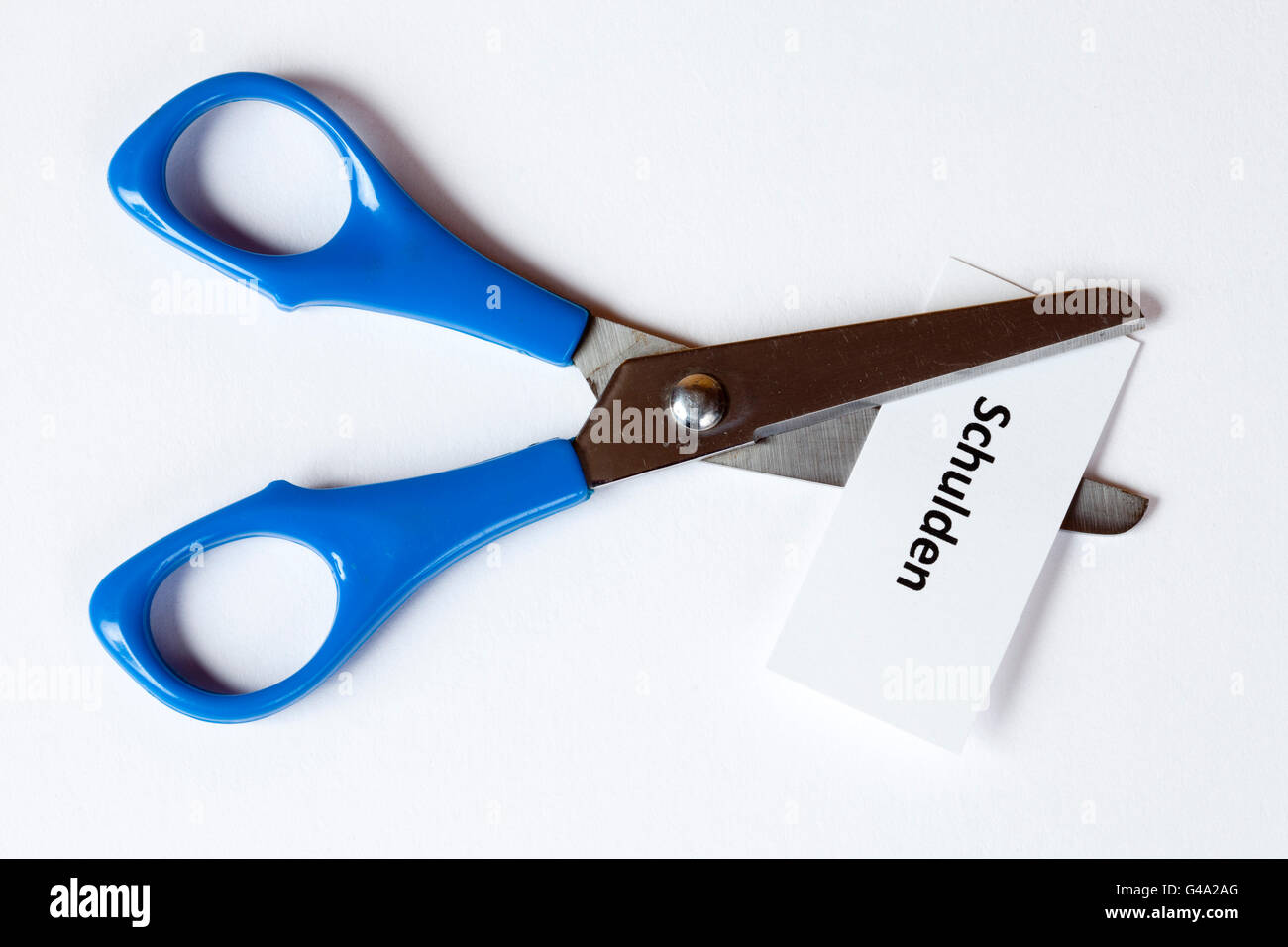 Scissors with the sign 'Schulden', German for 'debts', symbolic image for cutting debt Stock Photo