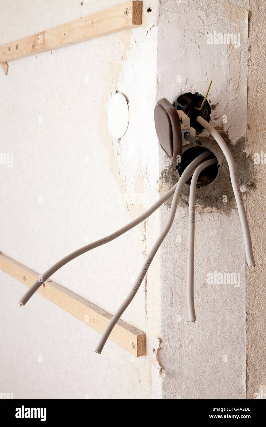 Power outlets with power cables and a light switch hanging out