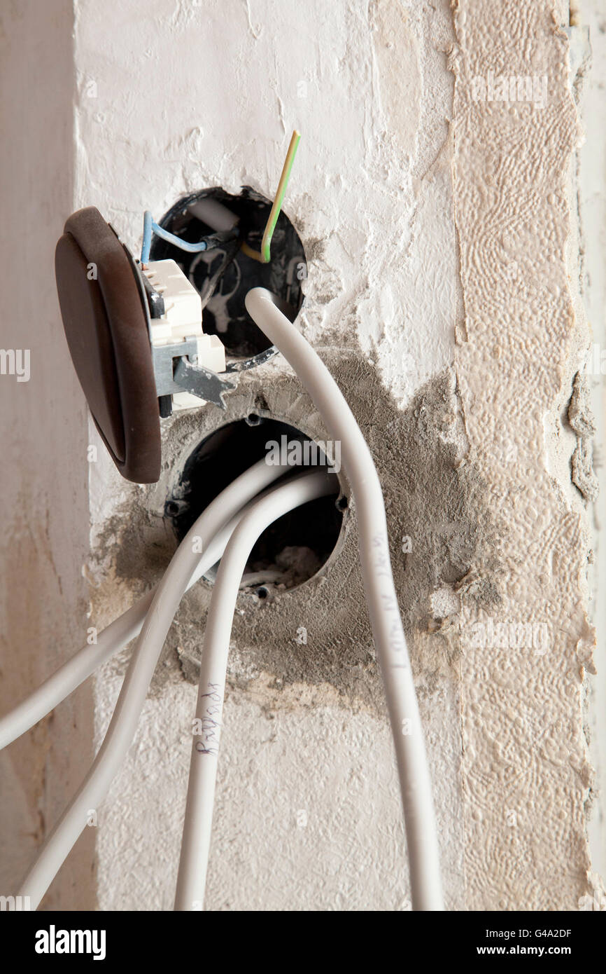 Power outlets with power cables and a light switch hanging out