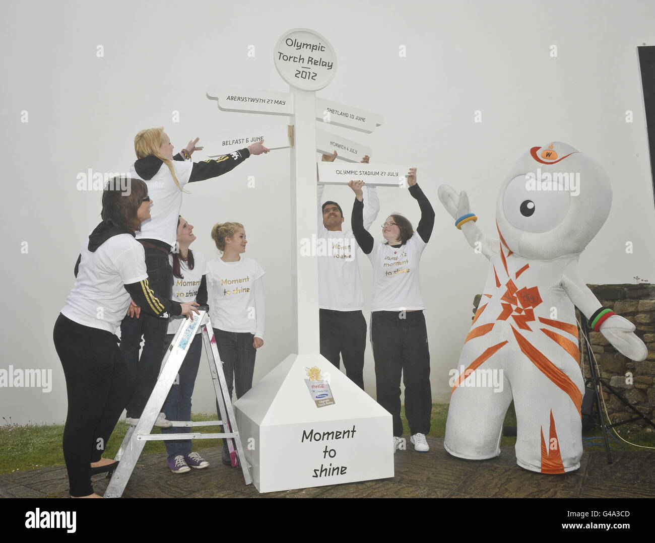 The Olympic mascot helps gold young ambassadors from across the UK place signs into the mock-up signpost at Lands End, Cornwall to mark the official announcement of the Olympic torch relay route across the UK. Stock Photo