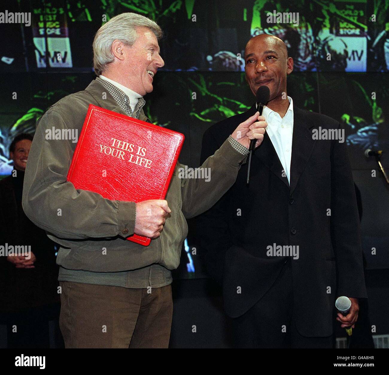 This is Your Life presenter Michael Aspel (left) presents Hot Chocolate singer Errol Brown with the Big Red Book at London's HMV Store in Oxford Street. 21/10/03: It has been announced the TV show This Is Your Life has been axed after almost 50 years.The first episode of the show was broadcast in 1955 and was presented by Eamonn Andrews, but the classic programme is now hosted by Michael Aspel.In its heyday the show regularly pulled in 20 million viewers. But the last edition of the programme in August this year, featuring former choirboy Aled Jones, was watched by just 3.5 million. Stock Photo