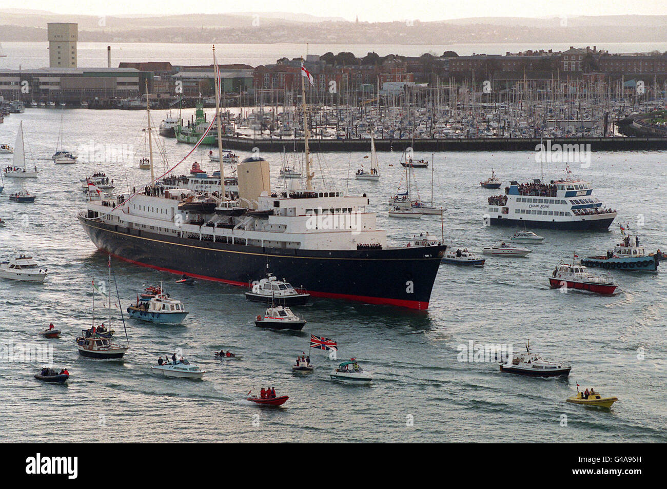 The Royal Yacht Britannia sails into Portsmouth today (Saturday) for the last time before she is decommissioned next month. Thousands of people lined the shore and gathered at the entrance to the harbour to witness the historic moment as the grand old lady of the seas arrived at the end of her farewell tour of Britain. Photo by Rebecca Naden/PA. See PA story ROYAL Yacht Stock Photo