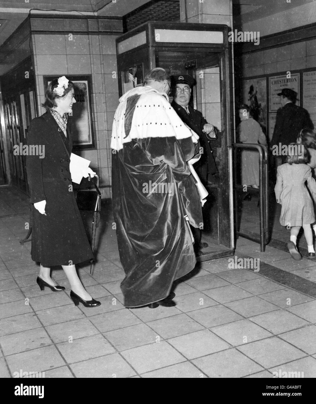 Wearing his Coronation robes Lord Leconfield is seen passing the ticket inspector at High Street Kensington Underground station. He traveled to Westminster Underground by the special 'Silver Train', the only train to stop at Westminster for the Queen's Coronation. *Damaged Negative* Stock Photo