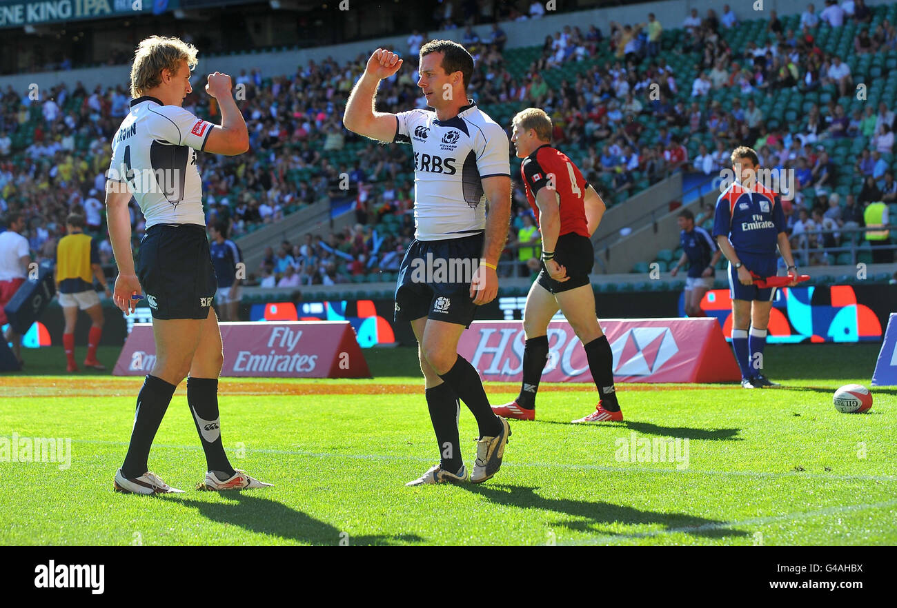 Scotland's Andrew Skeen (centre) celebrates with Scotland's Tom Brown (left) after scoring the opening try of match 17 of the IRB Emirates Airline London Sevens at Twickenham Stadium, London. Stock Photo