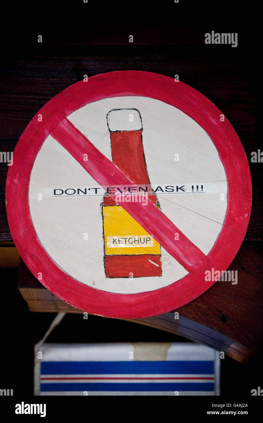 A sign warning customers to not ask for ketchup hangs on the wall at Louis' Lunch hamburger joint in New Haven, CT, USA, 26 May Stock Photo