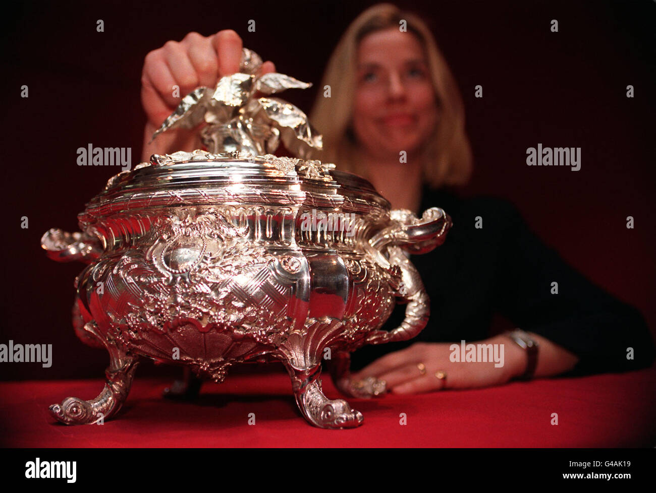 PR consultant Alex Hammersley keeps the lid on the Drury-Lowe Tureen at Sotheby's in London today (Monday). The silver tureen, which dates back to 1736, is part of a large silver collection made by England's greatest 18th century maker, Paul de Lamerie, due to be auctioned in New York and London later this year. It is expected to fetch between 500,000 and 800,000 alone. Photo by John Stillwell/PA Stock Photo