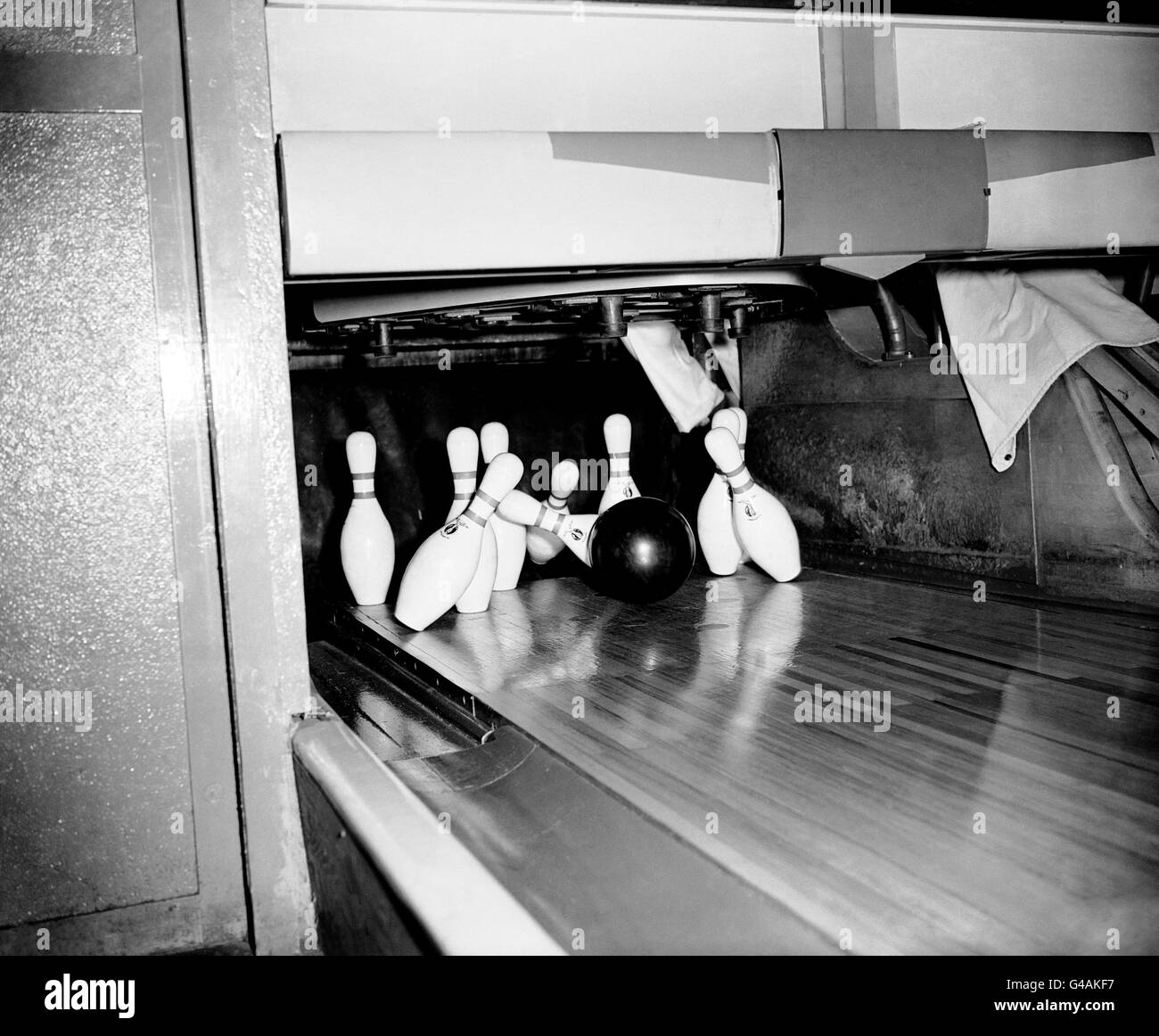 Ten Pin Bowling - United States Air Force Base - Ruislip. The 16lb solid rubber ball sends the pins flying during a game of ten pin bowling. Stock Photo