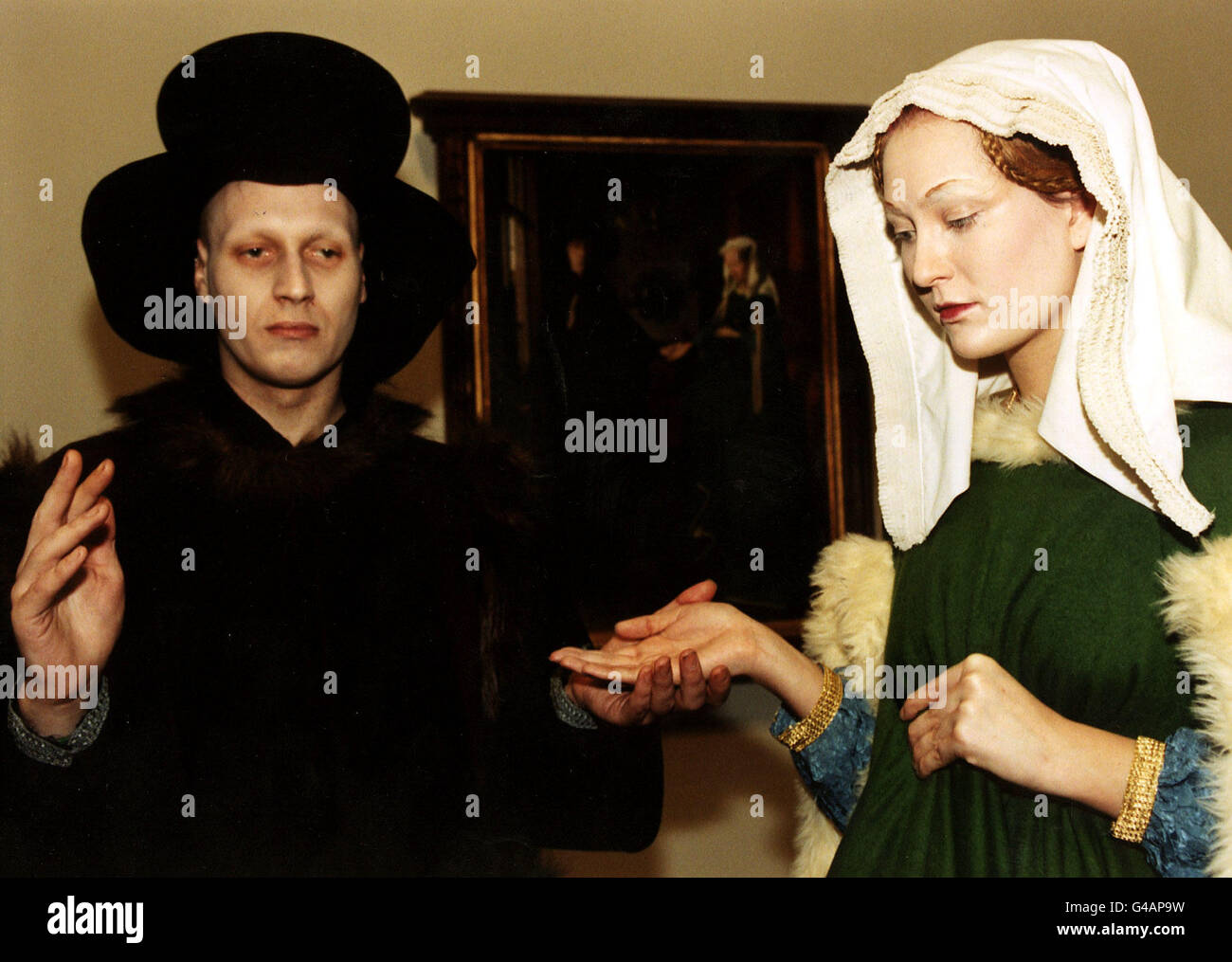 PA NEWS PHOTO 09/01/98 DRESSED IN COSTUMES, TWO MODELS POSE IN A RECREATION OF A JAN VAN EYCK PAINTING DURING A SPECIAL ONE DAY EXHIBITION AT THE NATIONAL GALLERY IN LONDON. IT WAS A JOINT PROJECT BETWEEN THE WIMBLEDON SCHOOL OF ART AND THE NATIONAL GALLERY Stock Photo