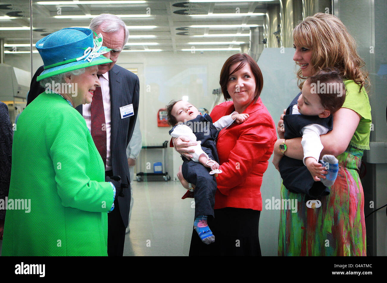 Queen Elizabeth II meets conjoined twins Hassan (left) and Hussein Benhaffaf along with their mother Angie (right) and Edward Kiely, the surgeon from Great Ormond St who performed the separation surgery in the Tyndall Institute in Cork city today, during the State Visit to Ireland. Stock Photo