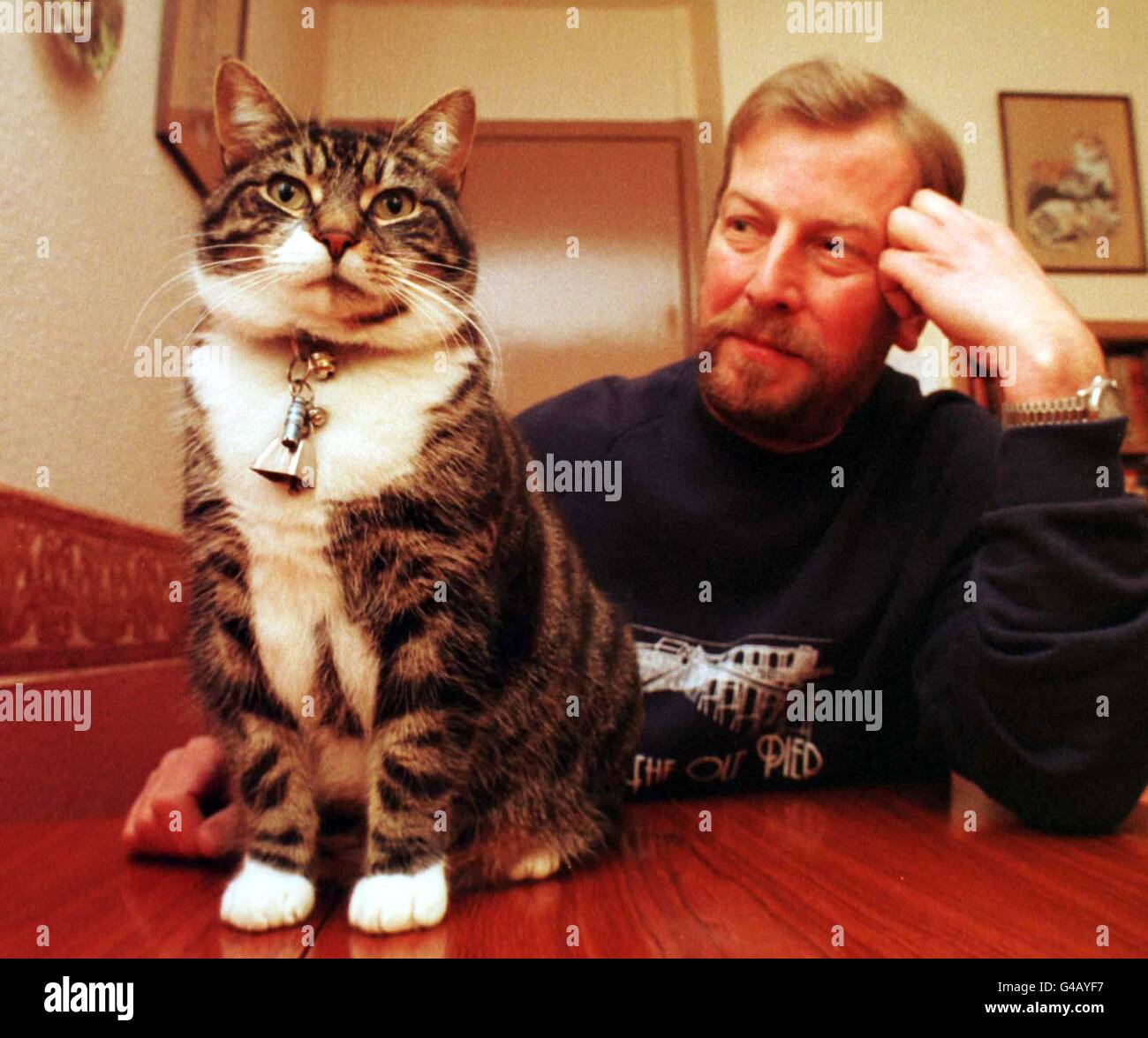 'Thomas' the cat with his owner Mike Davies at their Weston-Super-Mare home today (Thursday). Mr Davies was stunned to find an application form offering a new credit card landed on his doormat addressed to his tabby pet. The form, from Scottish Widows, offered his four-year-old feline a range of benefits including 170 annual savings, 56 days of interest-free credit and 90 days' purchase protection. See PA Story SOCIAL/Credit. Photo Barry Batchelor/PA. Stock Photo