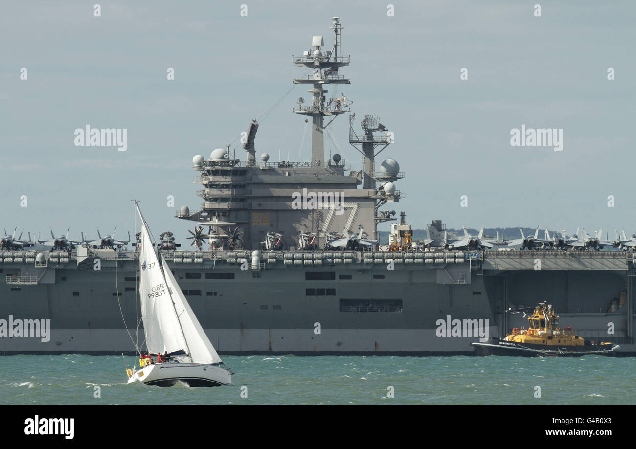 A boat sail past the United States Navy Nimitz-class supercarrier the USS George H.W. Bush in Stokes Bay off the coast of Portsmouth. PRESS ASSOCIATION Photo. Picture date: Friday May 27, 2011. Photo credit should read: Yui Mok/PA Wire Stock Photo