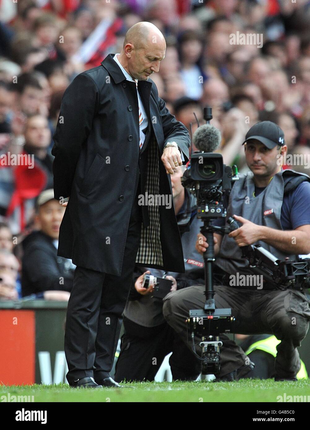 Soccer - Barclays Premier League - Manchester United v Blackpool - Old Trafford. Blackpool manager Ian Holloway checks his watch towards the end of the match Stock Photo