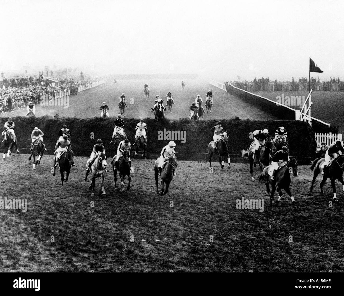 Horse Racing - The Grand National 1934 - Aintree Racecourse. The field jumping Becher's Brook, first time round Stock Photo