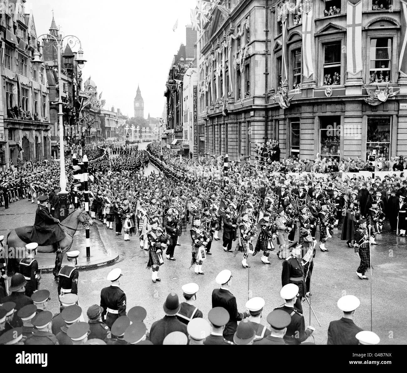 A pipe band combined from Scottish, Irish, Gurkhas and Indian forces, seen passing Charing Cross in the State procession as the Queen returned from her Coronation at Westminster Abbey. Stock Photo