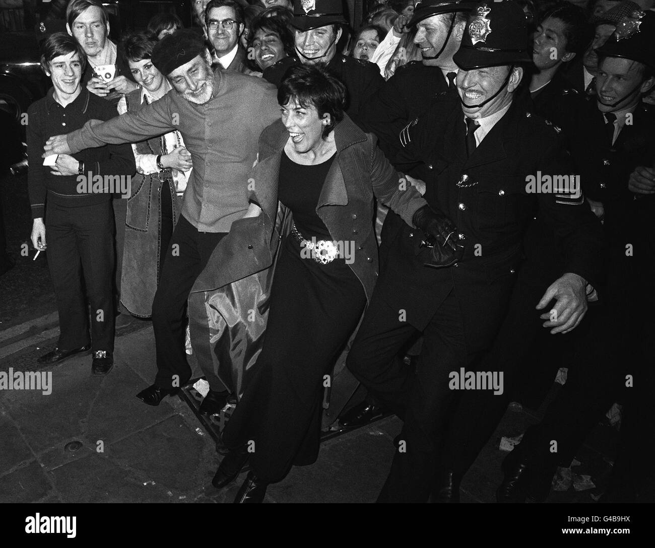 MAY 15th: On this day in 1970, The Beatles movie 'Let It Be' premieres in London. Comedian Spike Milligan and wife Patricia Ridgeway join hands with the police to keep surging crowds back at the premiere of 'Let It Be' at the london Palladium, Piccadilly Circus. Stock Photo