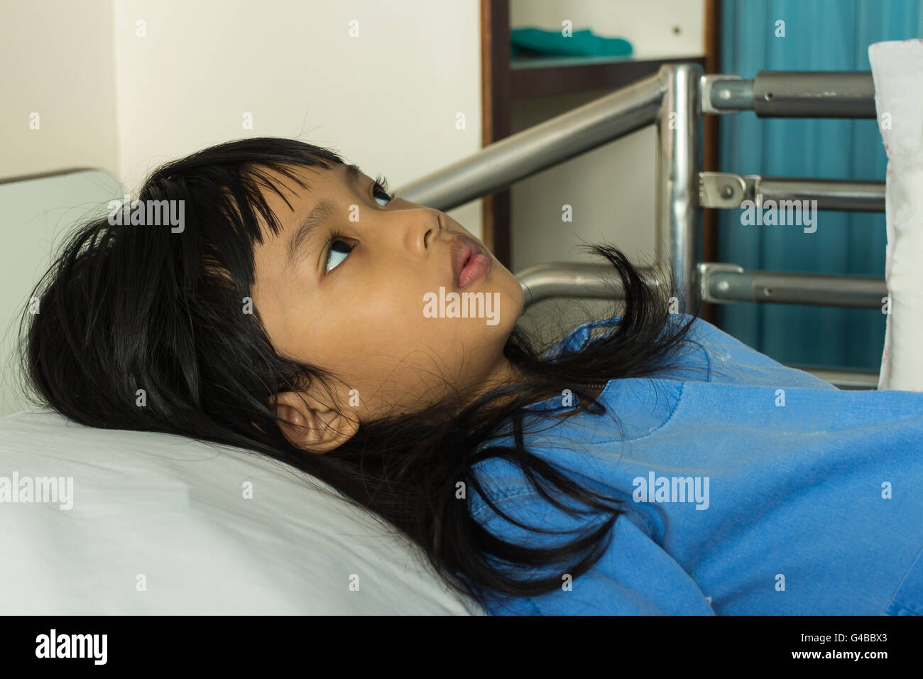Portrait of a sick girl lying in a hospital bed Stock Photo