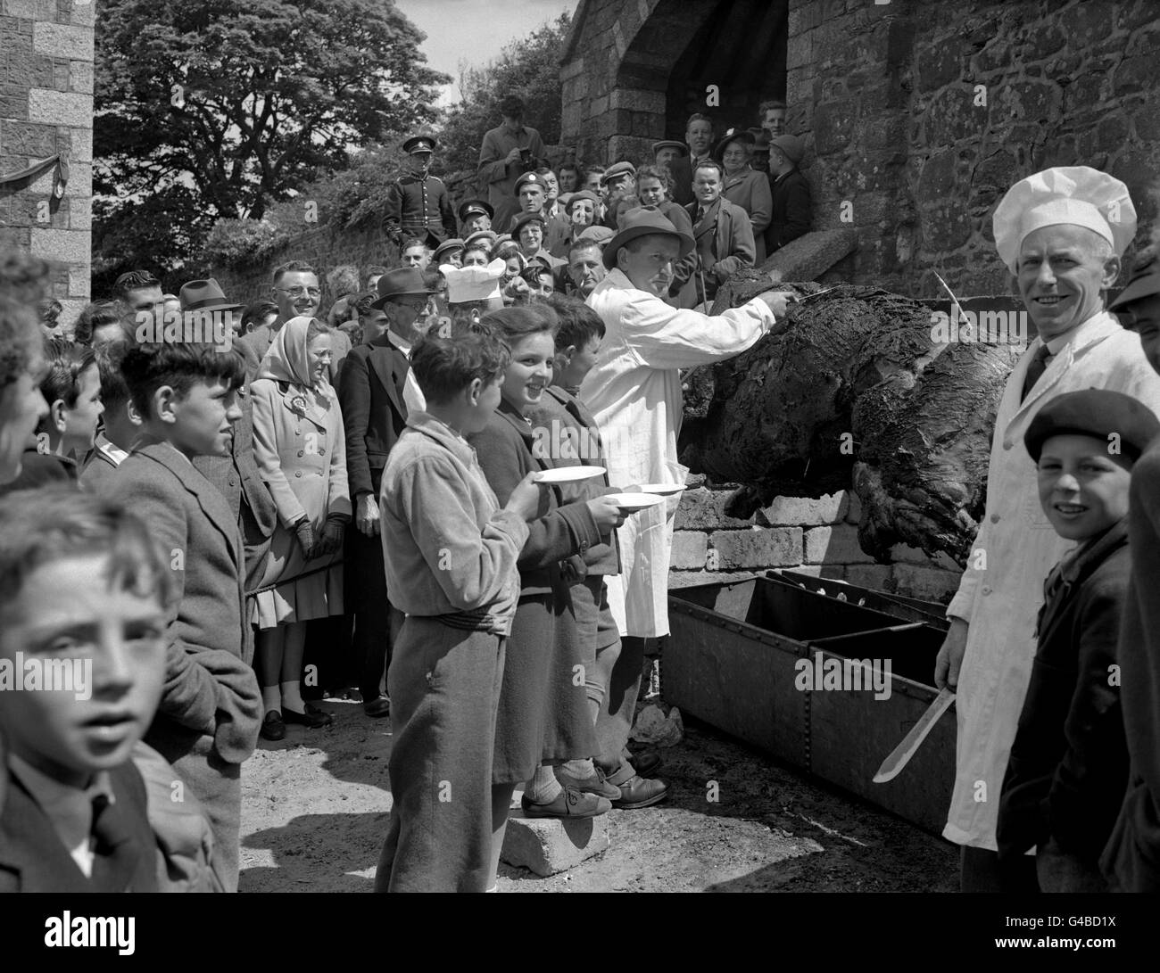 Villagers of St. Keverne in Cornwall, celebrated the Coronation in real old-English style. They roasted an ox in the village square. Stock Photo
