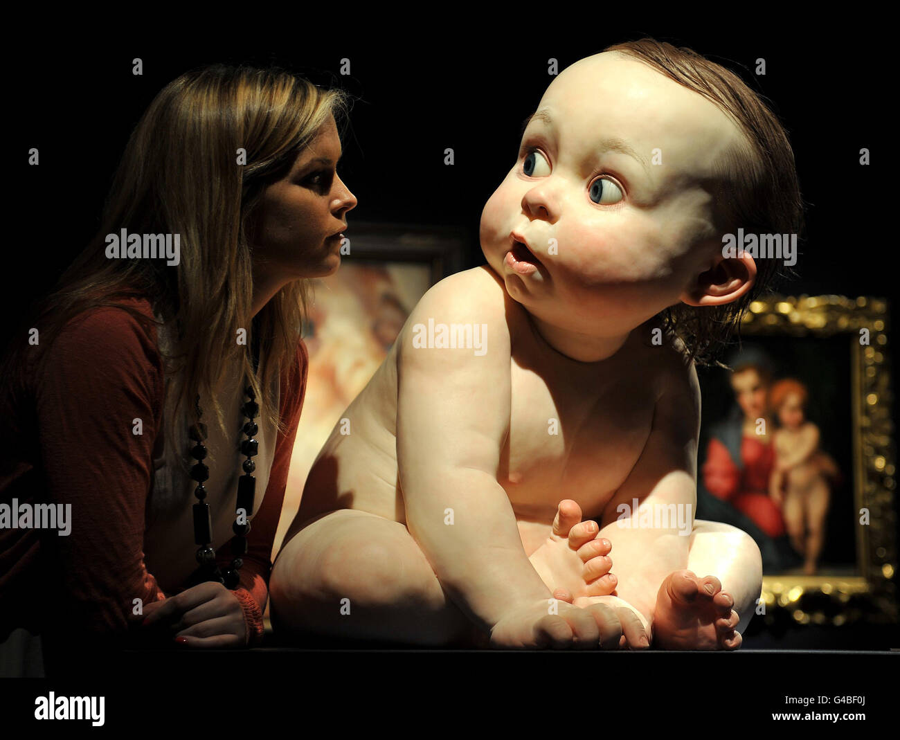 A young woman admires Big Baby by Ron Mueck, which is valued at between 800,000 to 1.2million and is one of several masterpieces that will launch a four week season of auctions expected to sell for 250million total, at Christie's in central London. Stock Photo