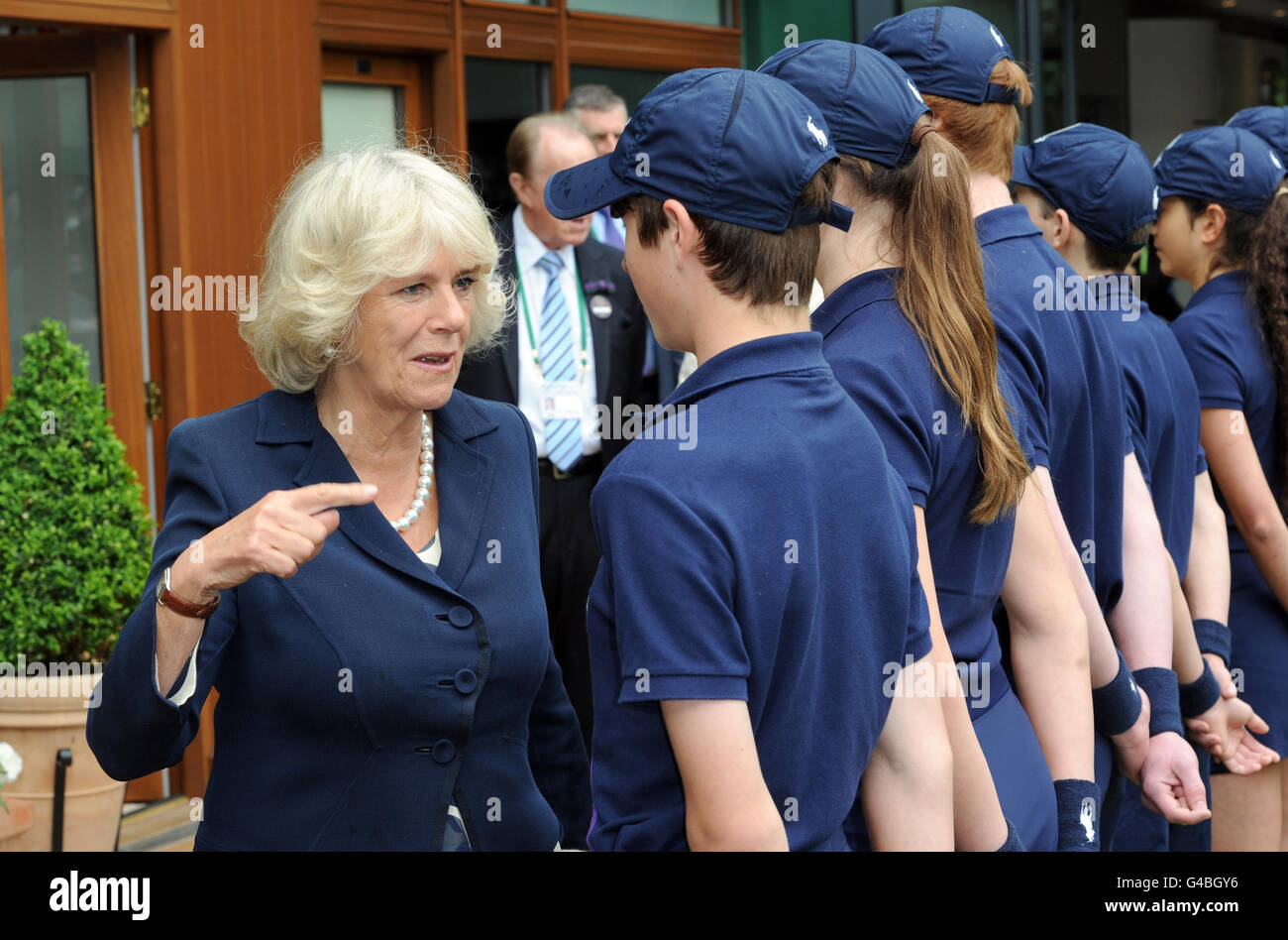 The Duchess of Cornwall speaks with Oscar King as she meets ball boys and girls during the third day of Wimbledon at the All England Lawn Tennis and Croquet Club, London. Stock Photo