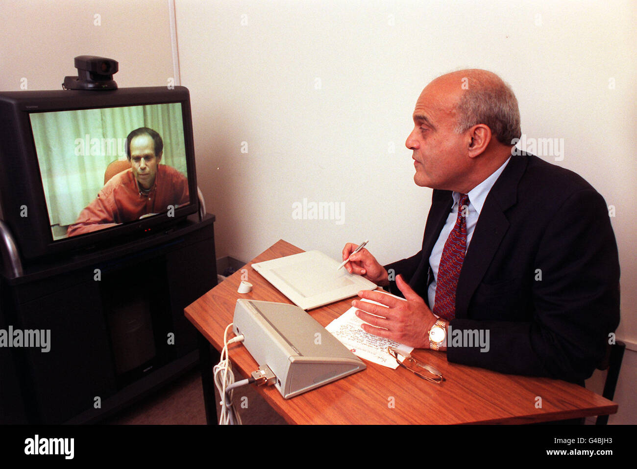World-renowned surgeon, Professor Sir Magdi Yacoub, at the Royal Brompton Hospital in London today (Thursday) shows that distance is no bar as he links up with his patient, Alan Piddington (on screen), via a corresponding tele-medicine machine at the Harefield Hospital. The brand new system means that doctors will be able to discuss effective diagnosis and treatment without time being spent travelling between different hospital sites. Photo by Ben Curtis/PA Stock Photo