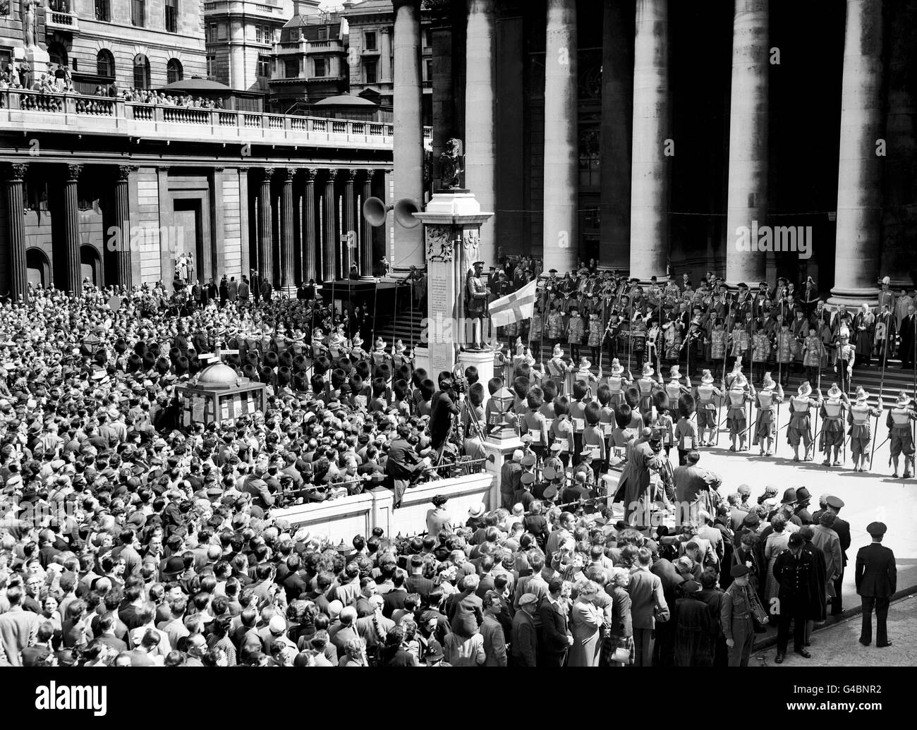 The Proclamation of the Coronation date of Queen Elizabeth II is read by Clarenceux King of Arms, Sir Arthur Cochrane, at the Royal Exchange, City of London. Facing the steps are pikemen of the Honourable Artillery Company. Stock Photo