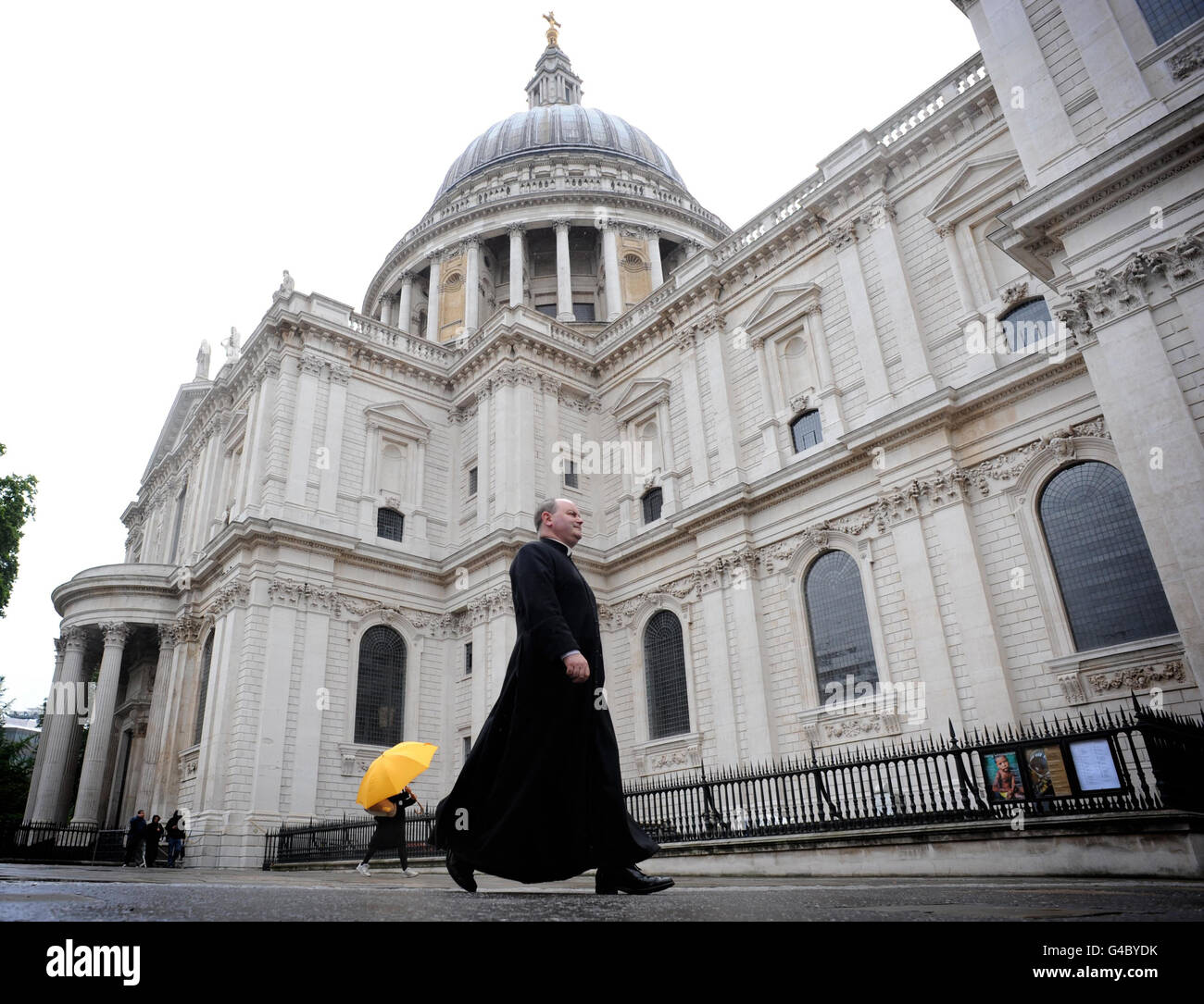 Canon Mark Oakley walks past St Paul's Cathedral in London which is celebrating its first day without scaffolding for 15 years after a £40 million restoration project. Stock Photo