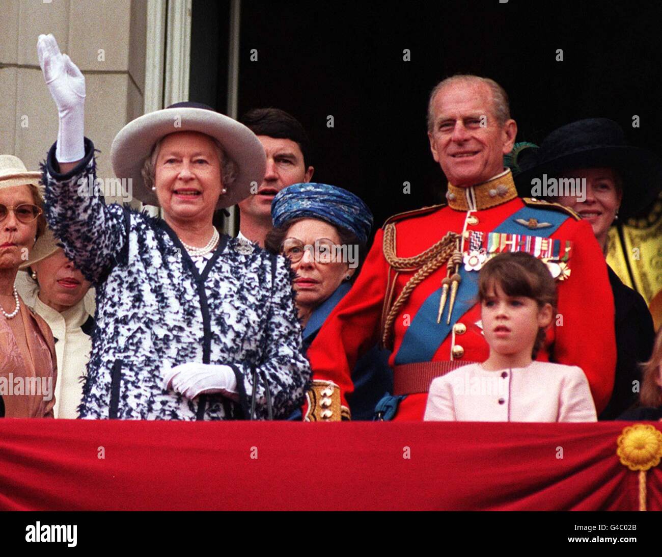 The Queen waves to the crowds as she stands on the balcony of Buckingham Palace with the Duke of Edinburgh and other members of the Royal Family after watching the traditional fly-past as part of the Trooping of the Colour in honour of the Her official birthday today (Saturday). Left to right: The Queen, Tim Laurence (Princess Anne's husband) Princess Margaret (wearing blue hat), The Duke of Edinburgh, Princess Eugenie (pink dress), Lady Helen Taylor (dressed in black), unidentified young girl and The Duke of Kent. See PA story ROYAL Trooping. WPA rota picture by John Stillwell/PA Stock Photo