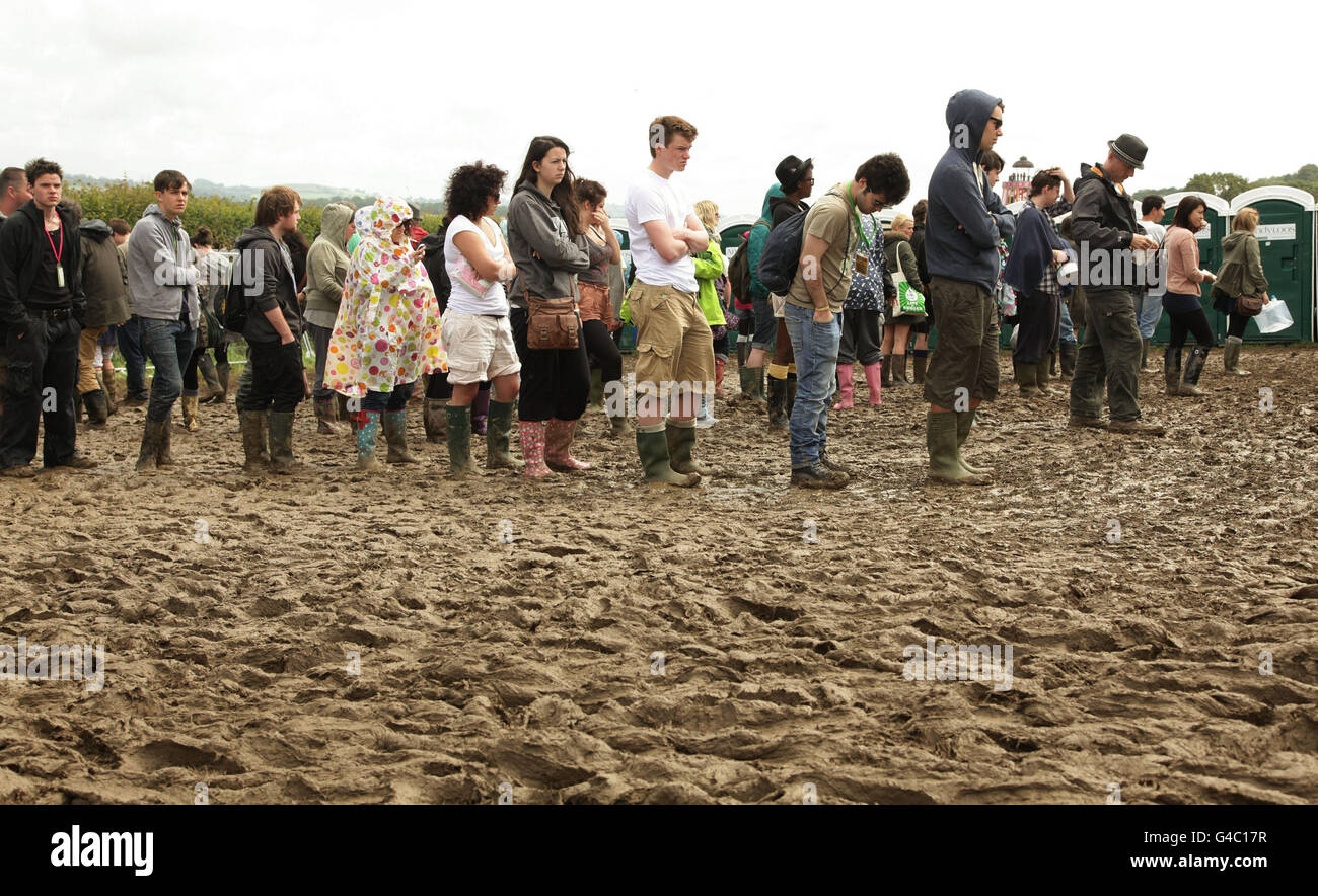 Festival goers queue for the toilets in the mud at the Glastonbury Festival in Somerset. Stock Photo