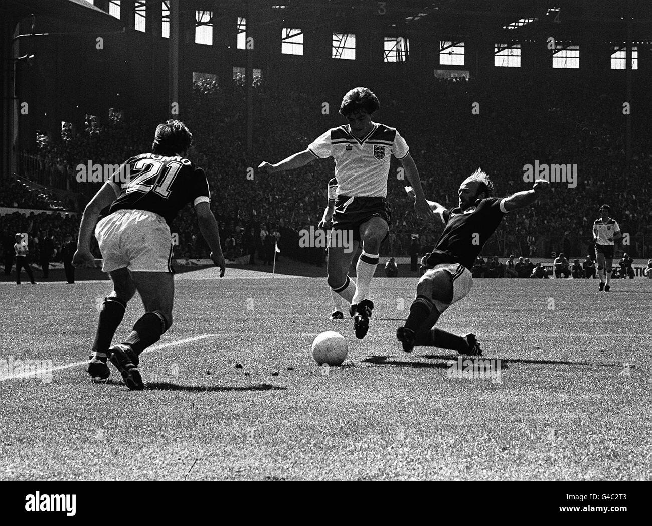 England's Steve Coppell (centre) retains possession despite the tackle from Scotland captain Archie Gemmill during the international match at Hampden Park, Glasgow. Stock Photo