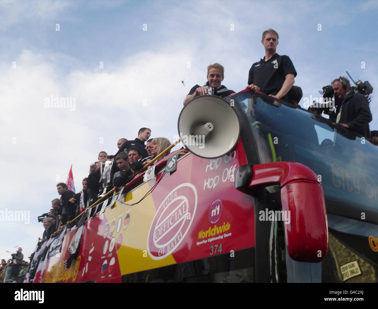 The Swansea City team on top of the bus after it arrived at Swansea Guildhall during the bus parade through Swansea. Stock Photo