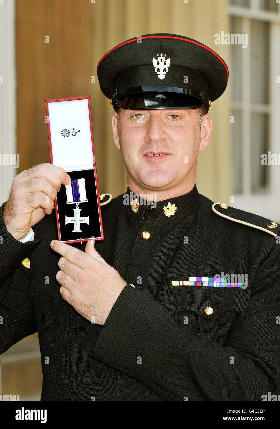 Lance Corporal Alan Redford proudly holds his Military Cross, after it was presented to him by Queen Elizabeth II at Buckingham Palace in central London following an Investiture Ceremony. Stock Photo