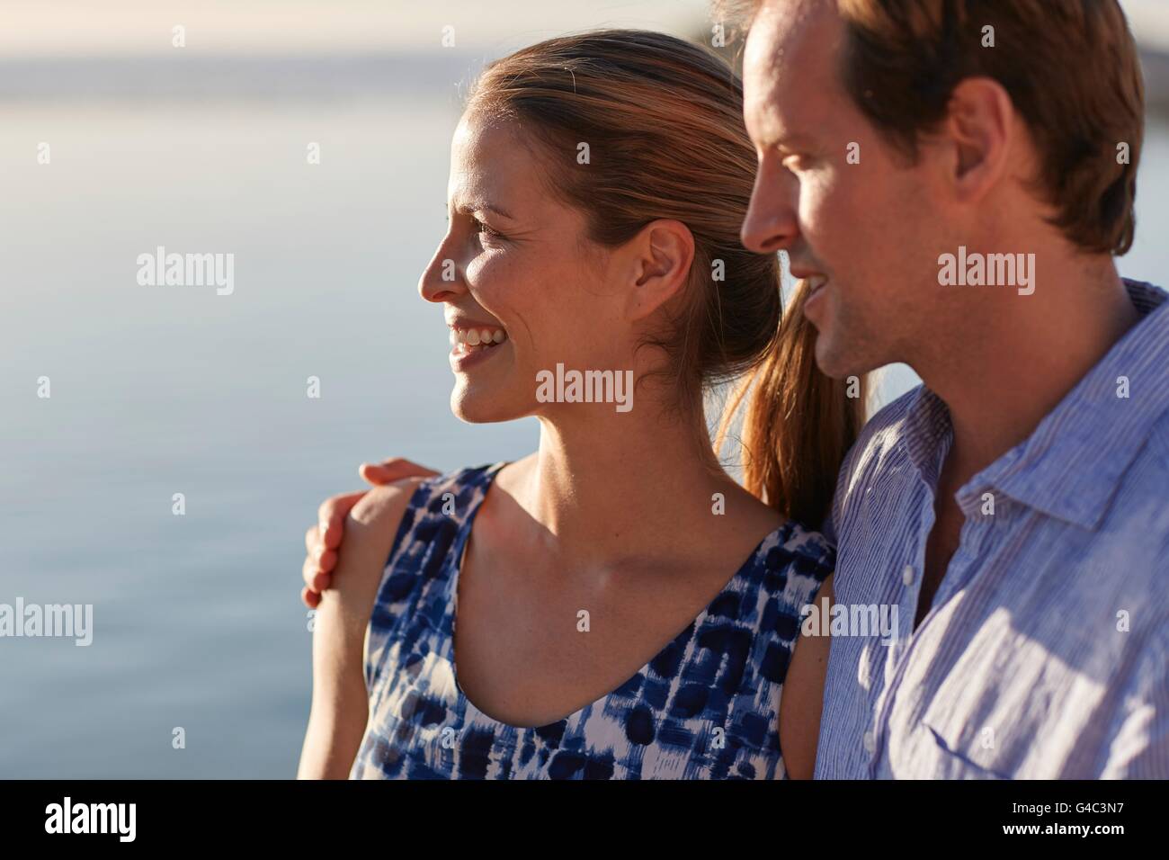 MODEL RELEASED. Couple looking at view, man with arm around woman. Stock Photo