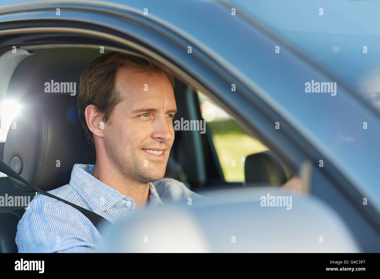 MODEL RELEASED. Mid adult man in car, smiling. Stock Photo