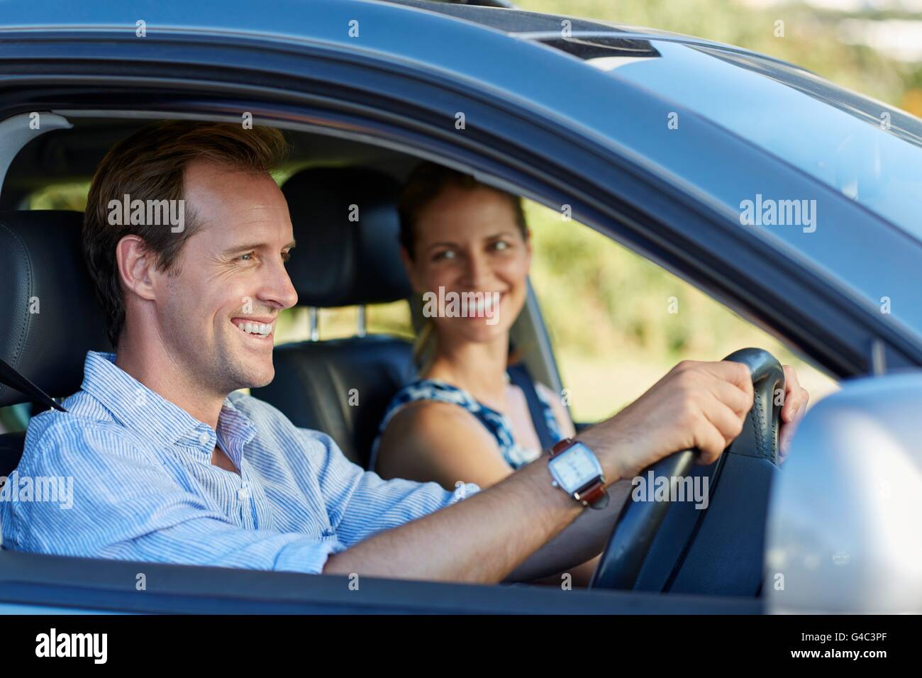 MODEL RELEASED. Couple driving in car, smiling. Stock Photo