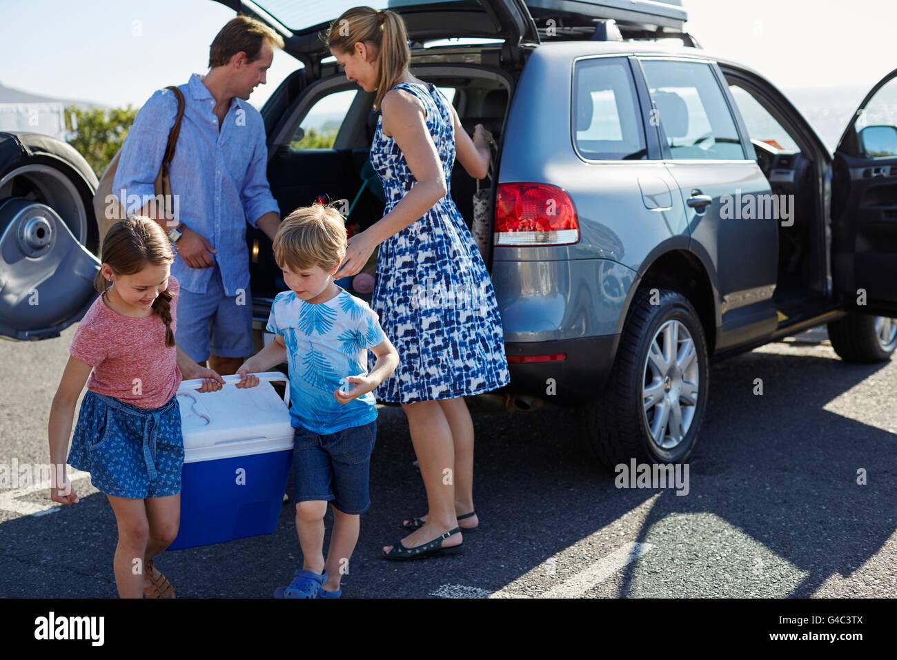 MODEL RELEASED. Family with two children unpacking the car. Stock Photo