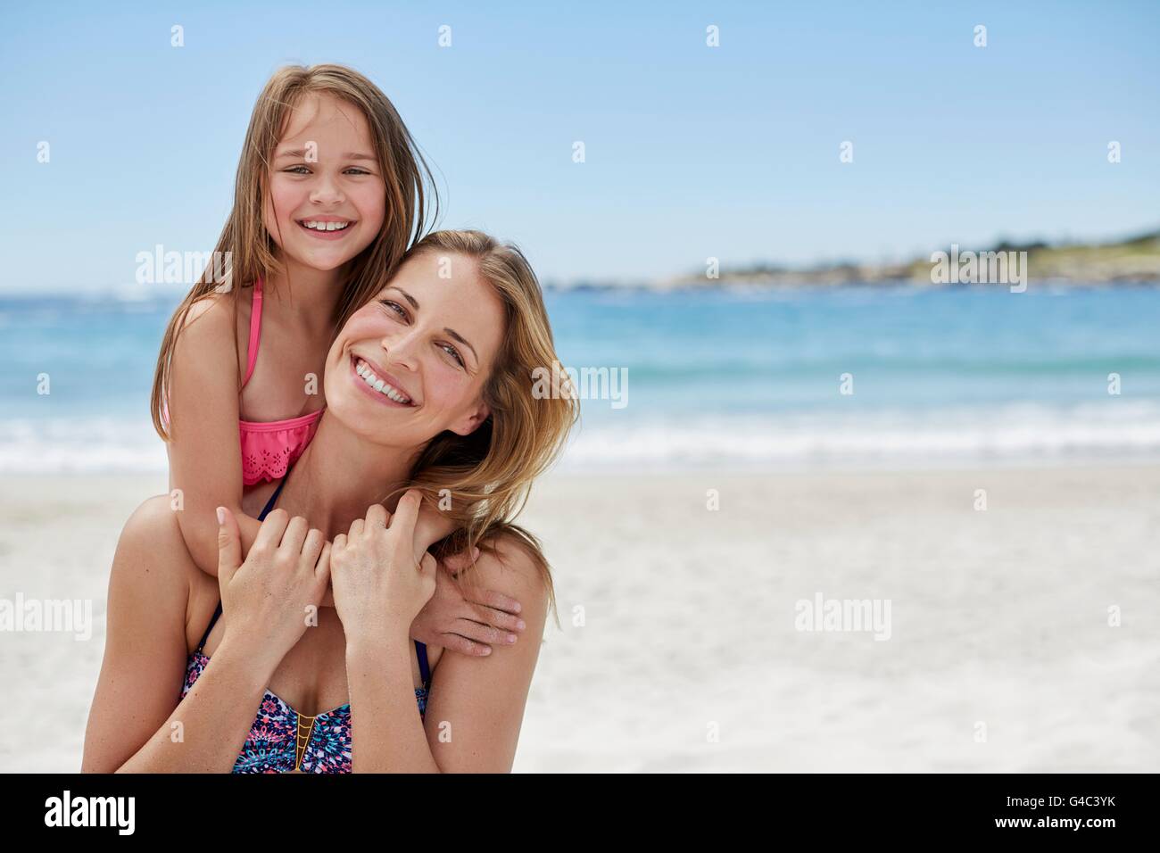 MODEL RELEASED. Mother carrying daughter on her back, portrait. Stock Photo