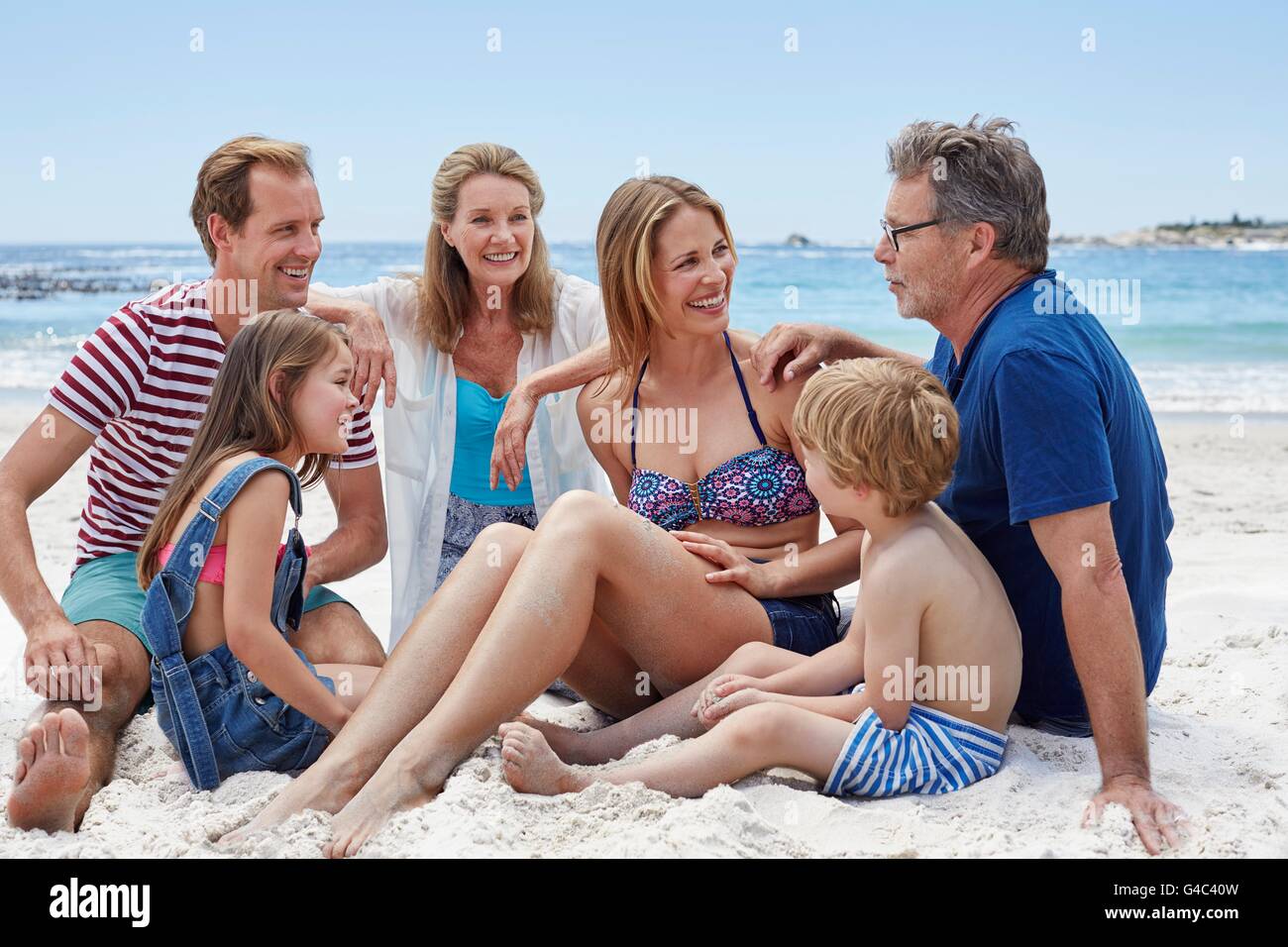 MODEL RELEASED. Three generation family sitting on the beach, portrait. Stock Photo