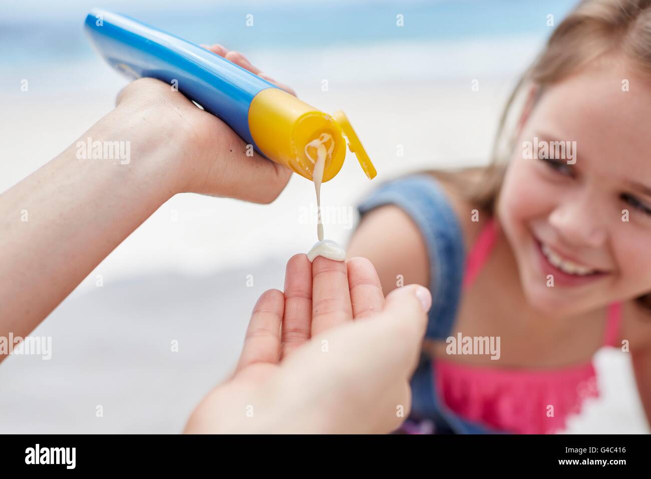 MODEL RELEASED. Person applying sun cream to a girl, close up. Stock Photo