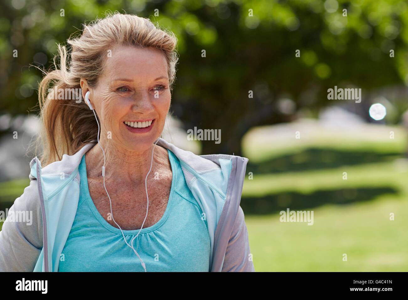 MODEL RELEASED. Senior woman exercising wearing earphones. Stock Photo