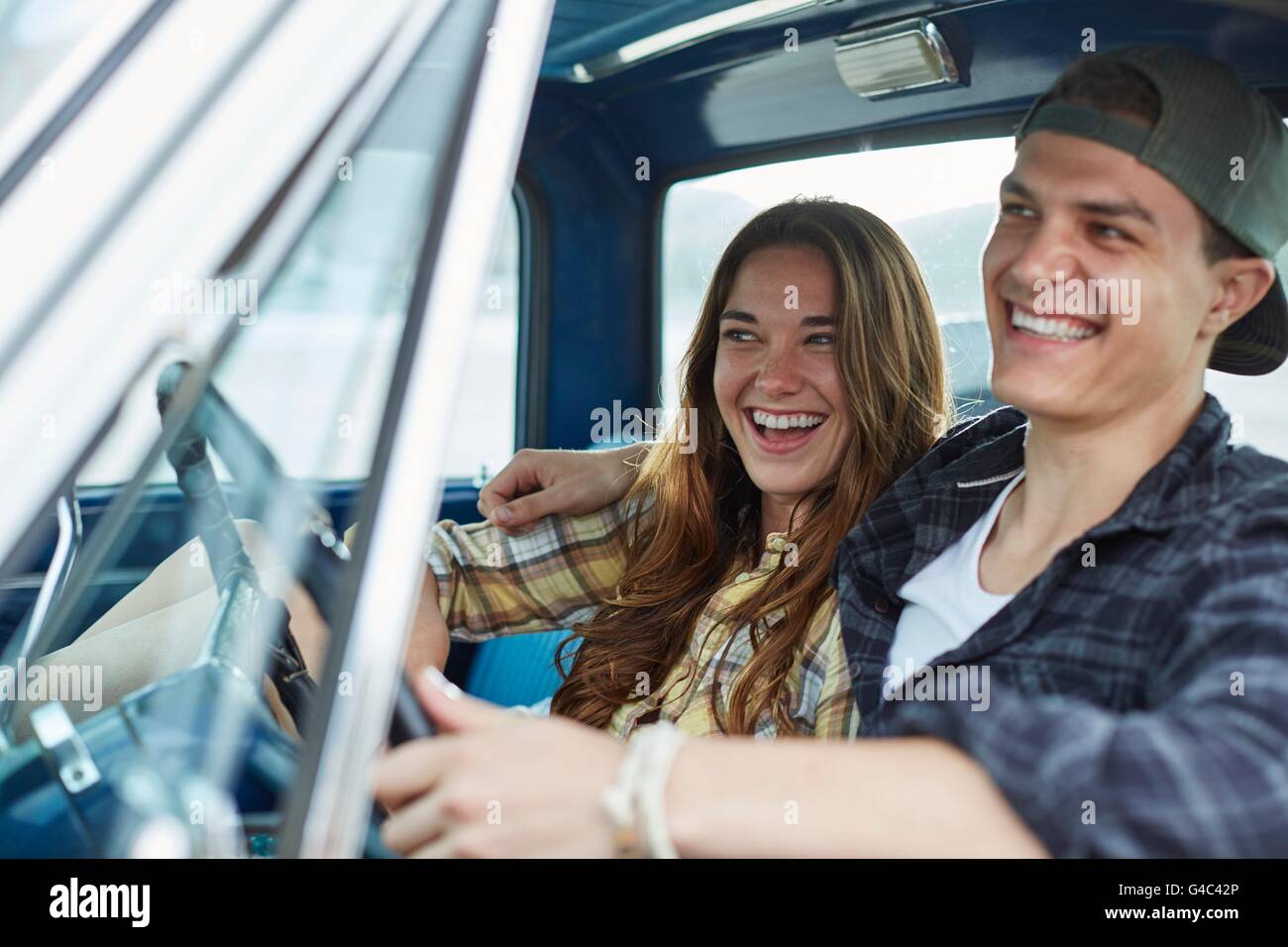MODEL RELEASED. Young couple in a car, laughing. Stock Photo