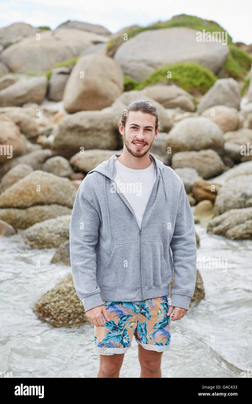 MODEL RELEASED. Young man on beach smiling towards camera. Stock Photo