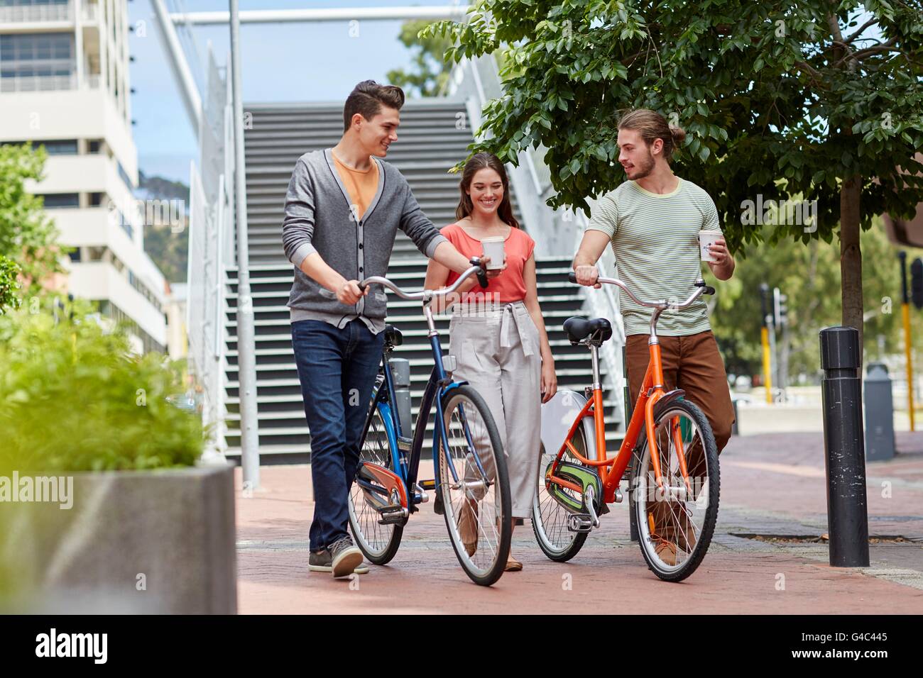 MODEL RELEASED. Young couple walking with bikes. Stock Photo