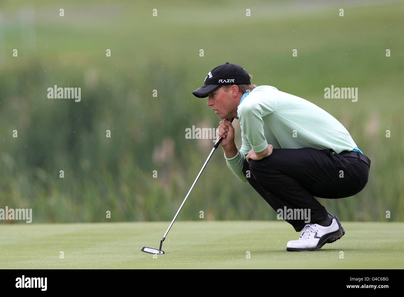 Sweden's Alexander Noren lines up a putt during day four of the Saab Wales Open 2011 at the Celtic Manor Resort, Newport. Stock Photo