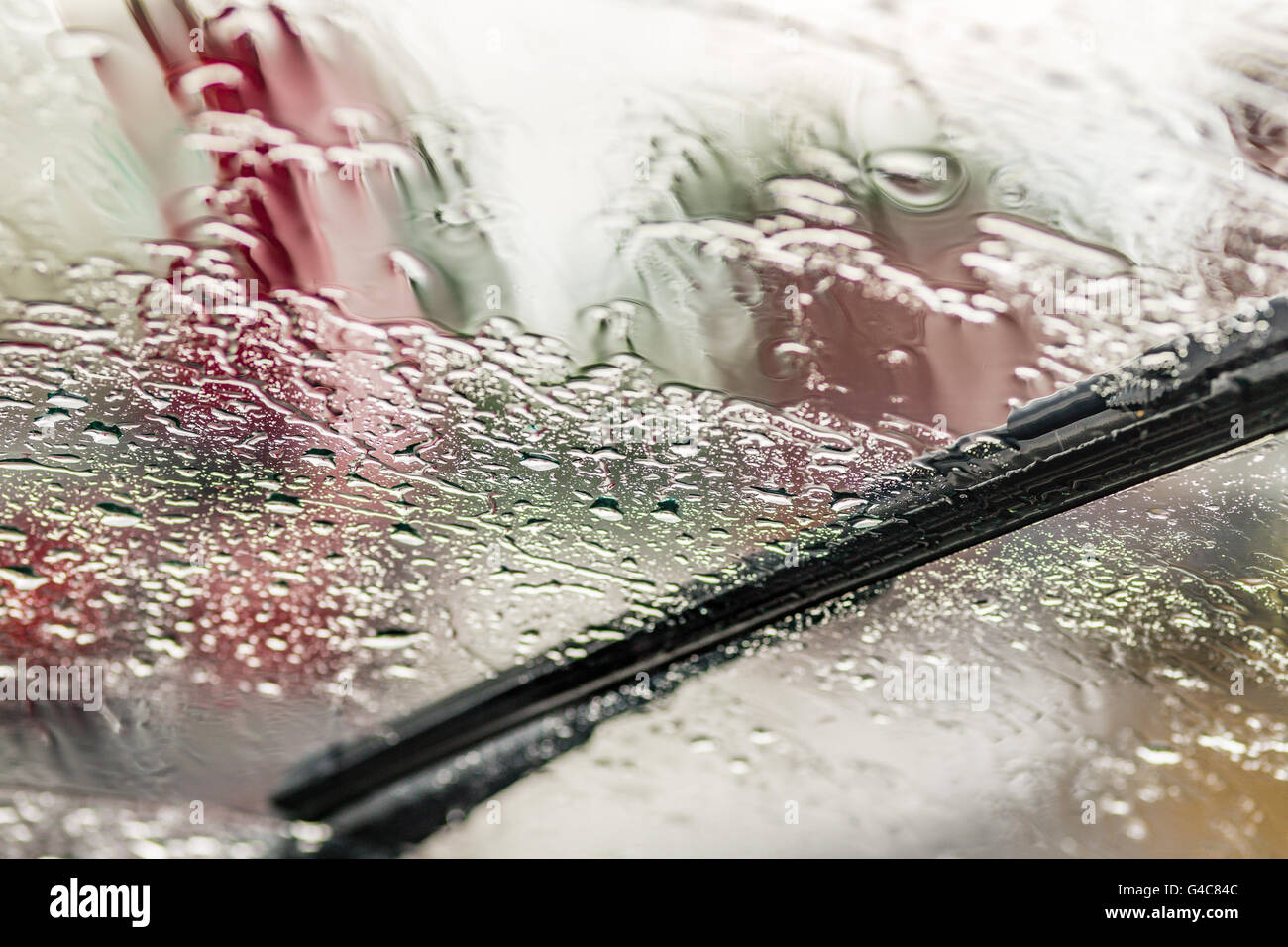 wiper stopped on fogged windshield and covered with drops of rain glass