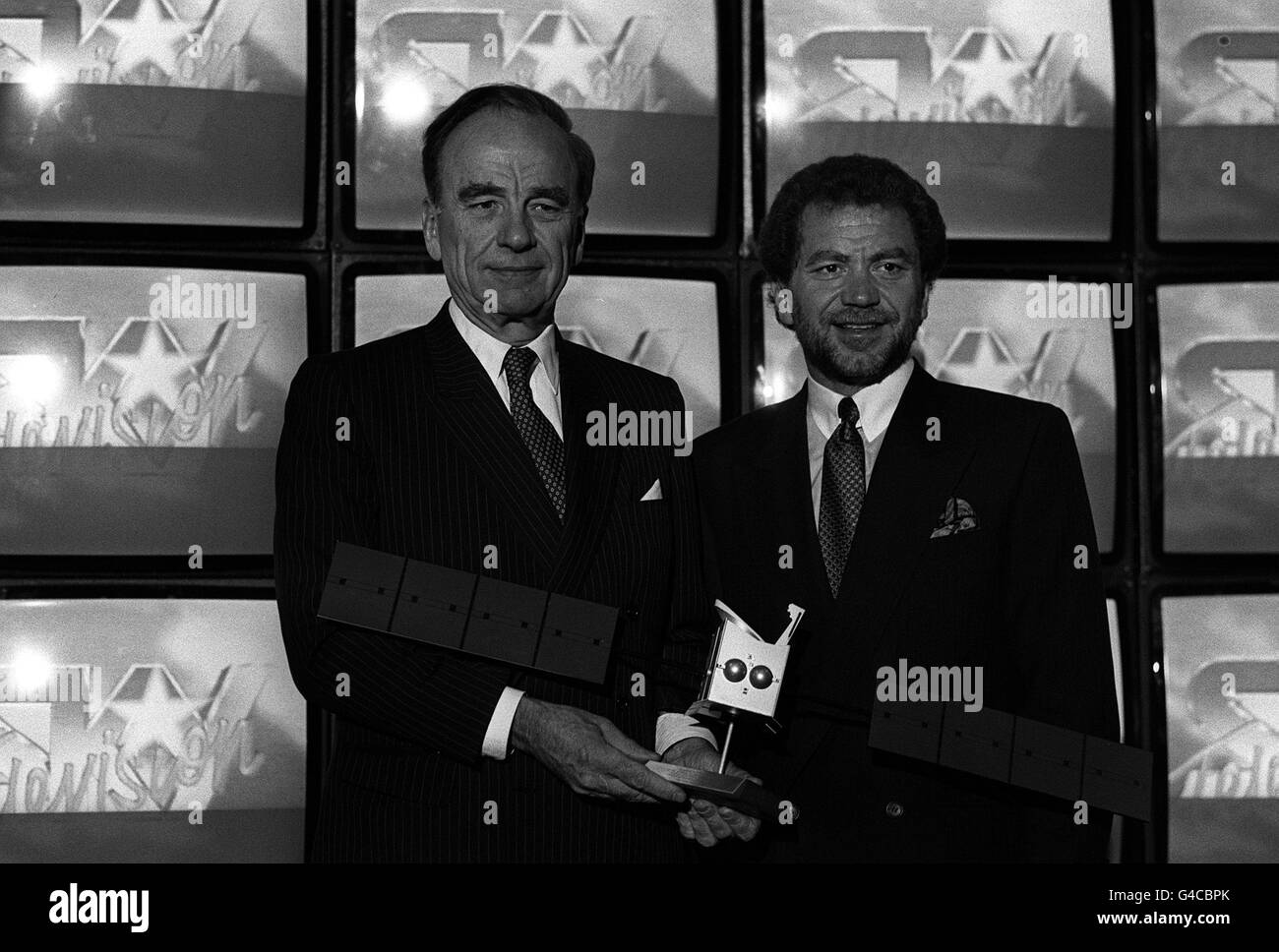 PA NEWS PHOTO 8/6/88 RUPERT MURDOCH AND ALAN SUGAR HOLDING A MODEL OF THE ASTRA SATELLITE AT A LONDON PRESS CONFERENCE TO ANNOUNCE THE 10 YEAR LEASE FOR THREE NEW SATELLITE CHANNELS, BY SUGAR'S AMSTRAD COMPANY Stock Photo