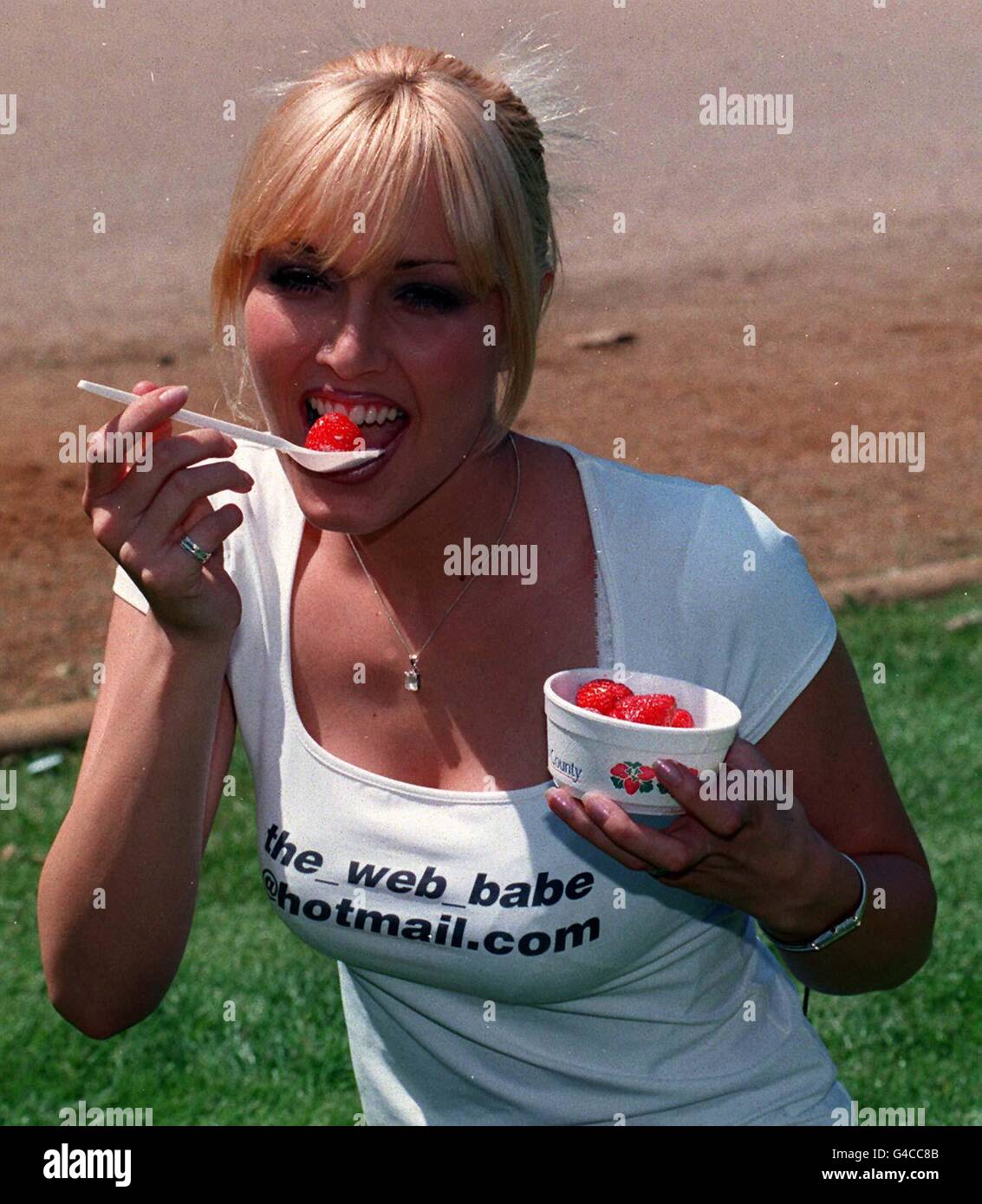 Model Emma Noble samples the strawberries during her visit to the Wimbledon Tennis Championships today (Wednesday) where she was promoting her feature on computer giant Microsoft's website. Fans of Ms Noble can gain an insight into her daily routine via 'Watch a day in the life of Emma Noble' at http://msn.co.uk' Photo by Michael Stephens/PA. Stock Photo