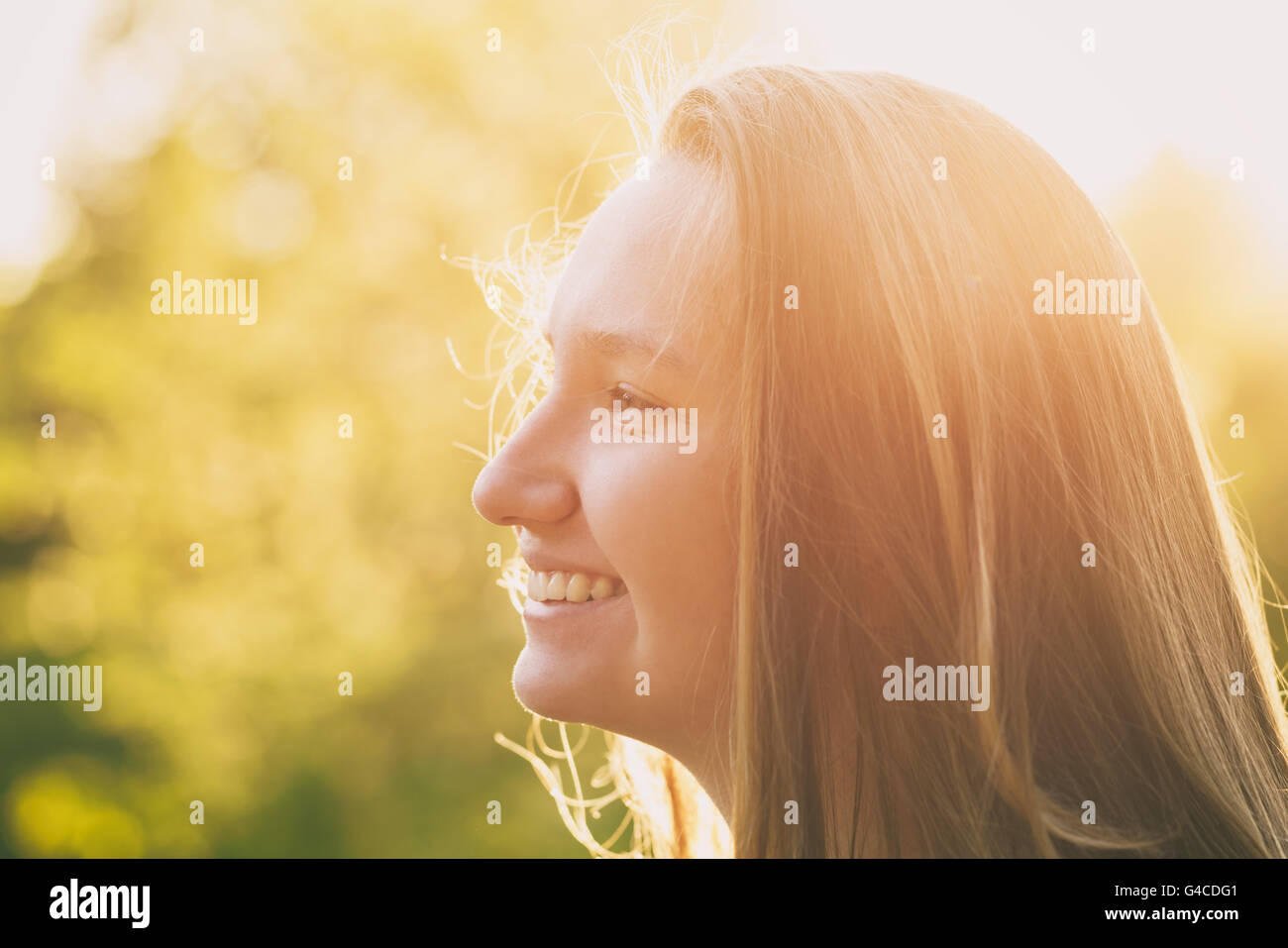 pretty teen girl smiling in warm sunset Stock Photo