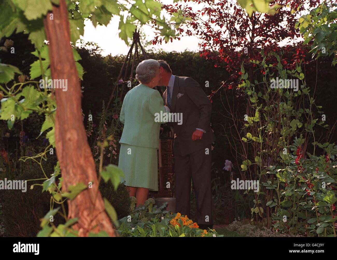 The Queen is greeted by her eldest son, Prince Charles, in 'Impressions of Highgrove, ' an exhibit based on the organic garden at Highgrove House, during their visit to the opening day of the annual Chelsea Flower Show in London today (Monday). See PA story SOCIAL Chelsea. Photo by John Stillwell/PA Stock Photo