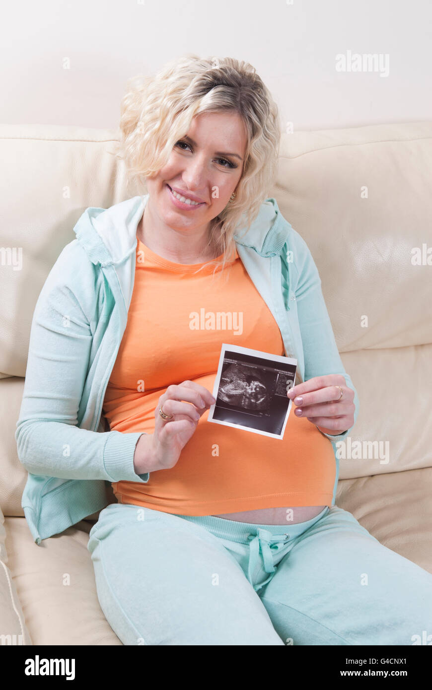 Pregnant woman holding a scan photo of her baby Stock Photo